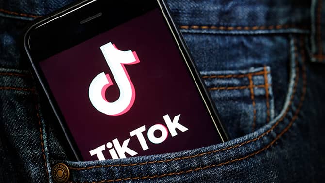 smartphone com a logo do TikTok no bolso da calça