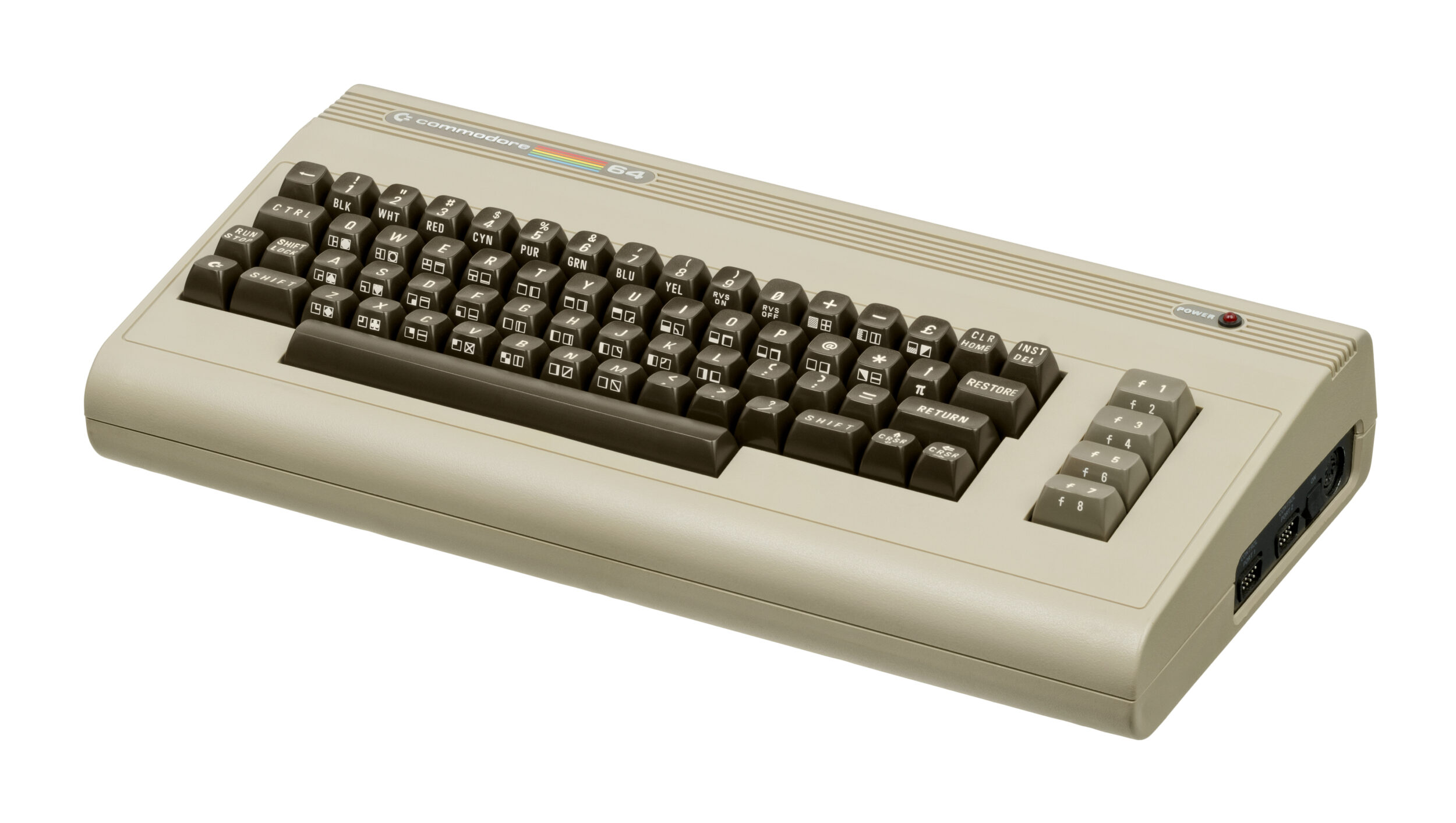 Computador Commodore 64 de cor bege, com teclado de teclas escuras e logotipo colorido da marca na frente, visto em ângulo